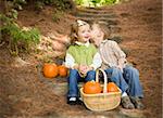 Adorable Brother and Sister Children Sitting on Wood Steps with Pumpkins Whispering Secrets or Kissing Cheek.