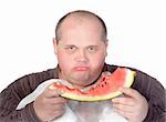 Obese man possessive of his food looking up from the slice of watermelon he is eating with a scowl and angry stare