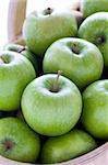 green granny smith apples in a trug close up