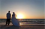 Hochzeit von einem Ehepaar, Braut und Bräutigam, zusammen bei Sonnenuntergang an einem wunderschönen tropischen Strand