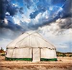 Yurt traditional nomadic house in central Asia at dramatic sky background