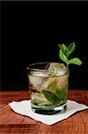 Mint julep isolated on a black background served on a bar top garnished with fresh mint