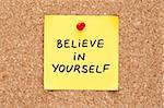 Believe In Yourself, written on an yellow sticky note on a cork bulletin board