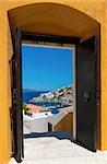 Blick auf den Hafen von der Insel Hydra, Griechenland, betrachtet durch eine offene Tür