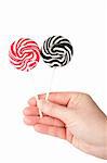 Hand holding two spiral lollipops isolated on white background