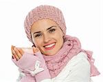 Glückliche Frau in stricken Schal, Mütze und Fäustlinge halten Tasse Tee