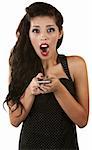 Excited young Latino woman holding cell phone over white