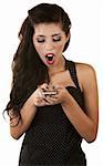 Surprised young woman looking at small cell phone