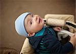 Portrait of the little boy sitting in the buggy and looking to the camera. Natural light, real colors, shallow DOF (prime 35mm L lense).