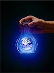 Man holding an old bottle with a glowing earth. Earth image provided by NASA.