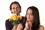Grinning woman and smiling man holding flowers
