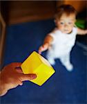 Petit garçon beau prend le cube jaune. Peu profonde dof, accent est mis sur le cube.