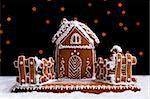 Gingerbread cookie house on dark background with blurry christmas lights