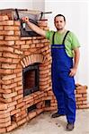 Worker building a masonry heater, mounting door - a danish mass stove