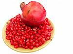 pomegranate (Punica granatum) fruit with seeds on a plate isolated on white