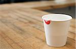 Papier tasse de café avec la marque de rouge à lèvres sur la jante