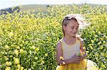 Jeune fille souriante, jouant dans le champ de fleurs