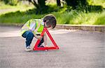 Boy playing traffic worker on rural road