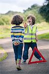 Boy playing traffic worker on rural road