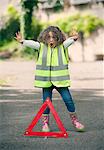 Girl playing traffic worker on rural road