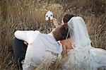 Newlywed couple holding a picture of a house