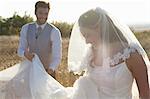 Newlywed groom holding brides dress