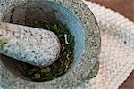 Herbs being ground in pestle and mortar