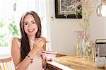 Smiling woman eating breakfast