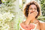 Smiling woman eating watermelon