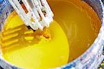 Vat of yellow paint being mixed