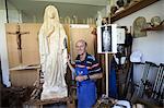 Sculptor standing with wood figure