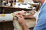 Worker applying gold leaf to pole