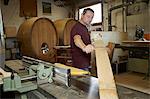 Worker examining wood in shop