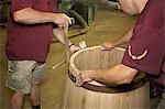 Workers hammering barrel in shop