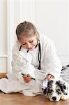 Girl playing doctor with dog