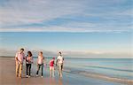 Famille marcher ensemble sur la plage