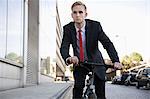 Schöner junger Geschäftsmann Fahrradfahren auf Straße