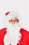 Portrait of man in Santa costume against gray background