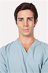 Portrait of confident young man in surgical scrubs over gray background