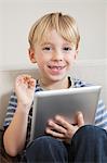 Young boy with digital tablet gesturing OK