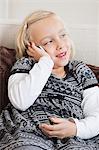 Young girl using cell phone on sofa