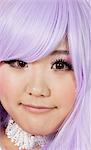 Close-up portrait of cute young woman with purple wig