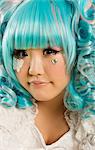 Close-up portrait of young woman with blue hair dressed as a doll