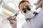 Dentist wearing Surgical Mask and Magnifier looking down, Germany