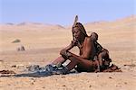 Himba Frau und Kind sitzt in der Nähe von Feuer, Namibia, Afrika