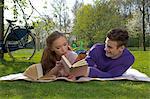 Young couple reading on a meadow