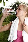 Blond young woman drinking water from bottle