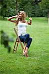 Young woman sitting at chair in garden