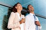 Businessman and businesswoman with coffee to go outdoors