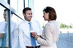 Businessman and businesswoman with coffee to go talking